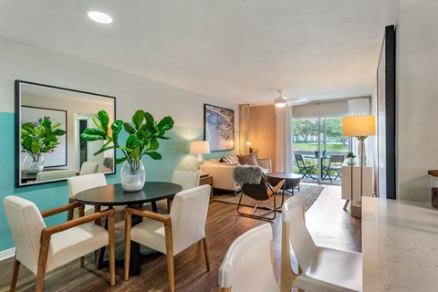 a living room and dining room with a table and chairs
